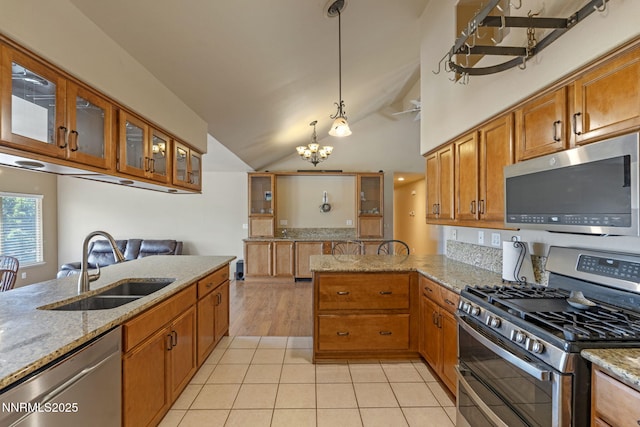 115 Stags Leap Cir, Spanish Springs, NV 89441 - kitchen with stainless steel appliances, brown cabinets, a chandelier, a peninsula, and light stone countertops