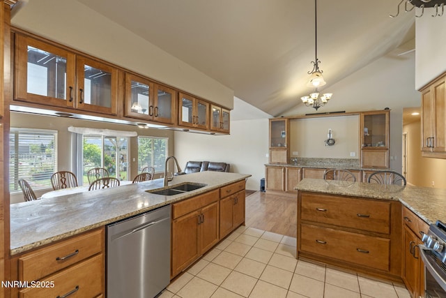 115 Stags Leap Cir, Spanish Springs, NV 89441 - kitchen featuring appliances with stainless steel finishes, brown cabinets, light stone counters, lofted ceiling, and a chandelier