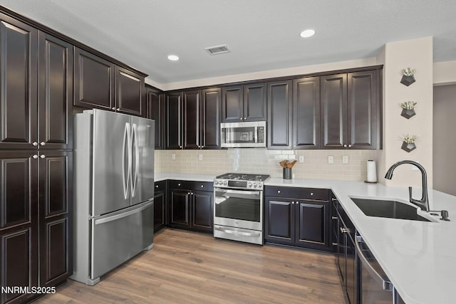 2064 Whitecliff Dr, Reno, NV 89521 - kitchen with appliances with stainless steel finishes, a sink, tasteful backsplash, dark wood finished floors, and recessed lighting