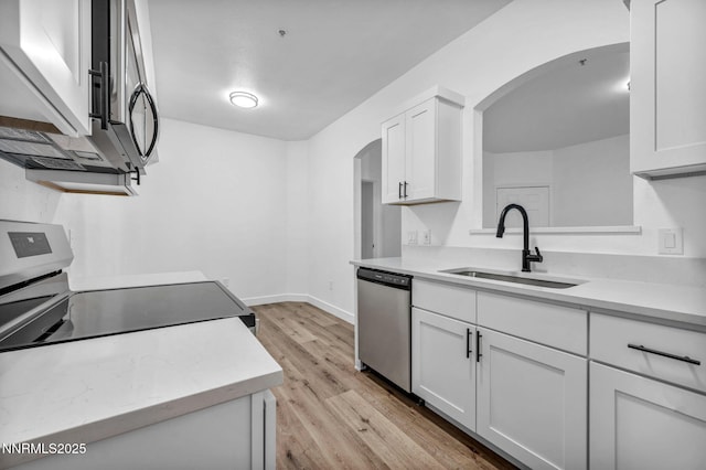 6850 Sharlands Ave # E1017, Reno, NV 89523 - kitchen featuring appliances with stainless steel finishes, arched walkways, white cabinets, and light wood finished floors