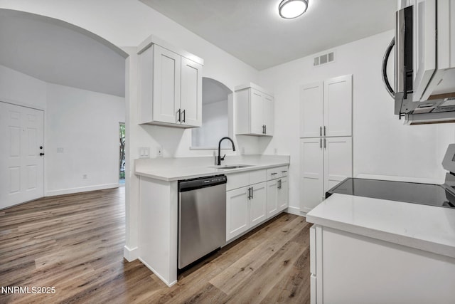 6850 Sharlands Ave # E1017, Reno, NV 89523 - kitchen with stainless steel appliances, arched walkways, light wood-style floors, and white cabinetry