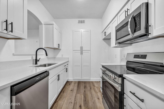 6850 Sharlands Ave # E1017, Reno, NV 89523 - kitchen featuring appliances with stainless steel finishes, light wood finished floors, light countertops, and white cabinets
