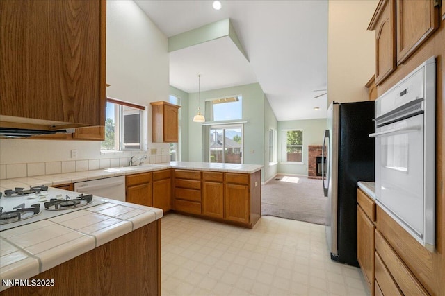 1290 Saddlehorn Ct, Minden, NV 89423 - kitchen featuring white appliances, a peninsula, tile counters, and light flooring