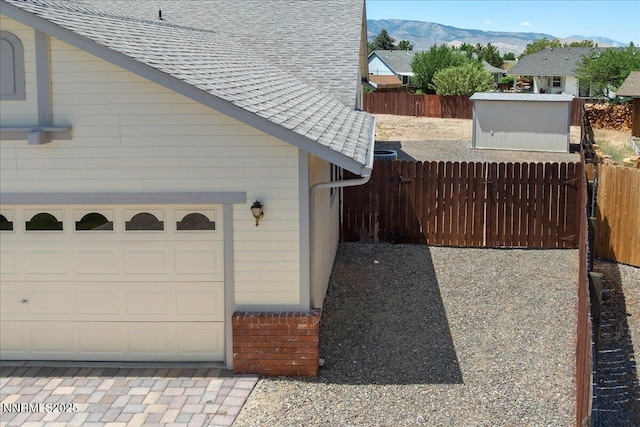 1290 Saddlehorn Ct, Minden, NV 89423 - view of property exterior with a mountain view, a shingled roof, and a garage