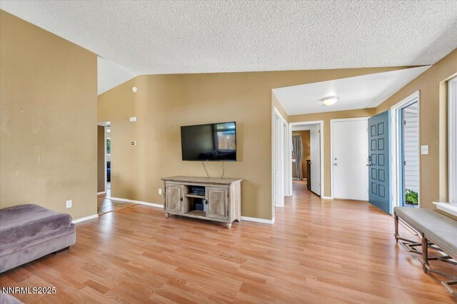 809 Glen Valley Dr, Sparks, NV 89434 - living area featuring light wood-style flooring, lofted ceiling, baseboards, and a textured ceiling