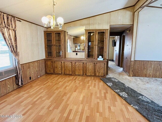 6480 Teal Dr, Fallon, NV 89406 - unfurnished dining area with wood walls, a chandelier, wood finished floors, lofted ceiling, and a wainscoted wall