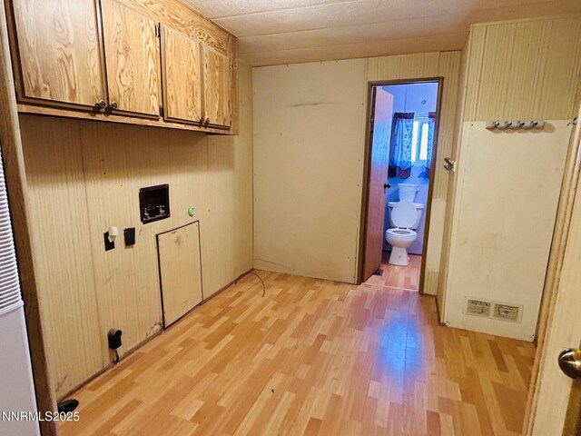 6480 Teal Dr, Fallon, NV 89406 - laundry room with cabinet space, light wood-style floors, and wooden walls