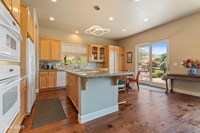 7601 Autumn Ridge Cir, Reno, NV 89523 - kitchen with white appliances, light brown cabinets, a kitchen island, glass insert cabinets, and a kitchen breakfast bar