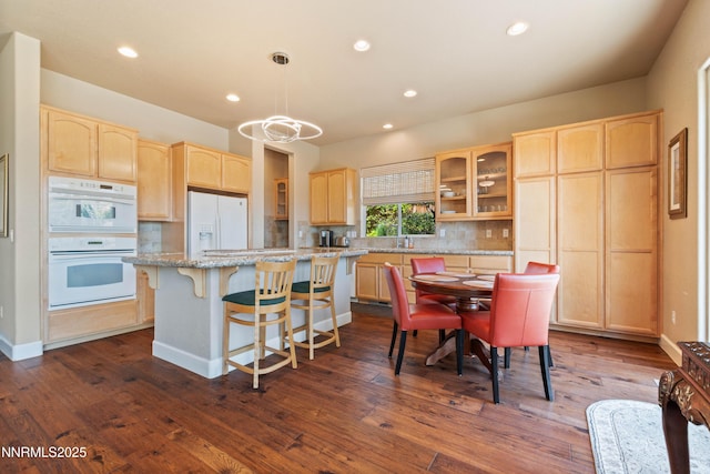 7601 Autumn Ridge Cir, Reno, NV 89523 - kitchen with white appliances, light brown cabinets, glass insert cabinets, decorative backsplash, and a center island