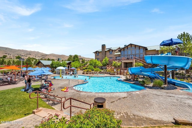 7601 Autumn Ridge Cir, Reno, NV 89523 - community pool featuring a water slide, a mountain view, a patio, and a yard