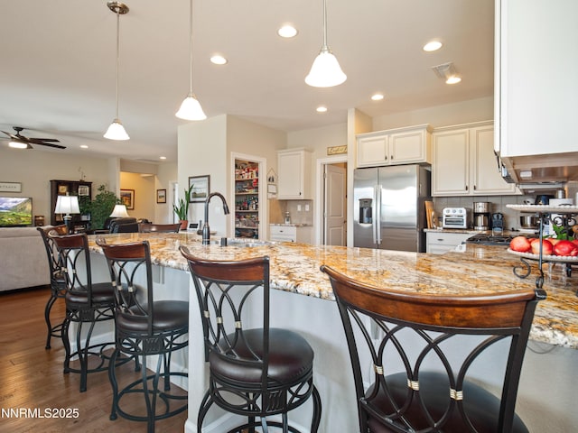 1221 Lasso Ln, Gardnerville, NV 89410 - kitchen featuring stainless steel fridge with ice dispenser, light stone counters, white cabinets, recessed lighting, and hanging light fixtures