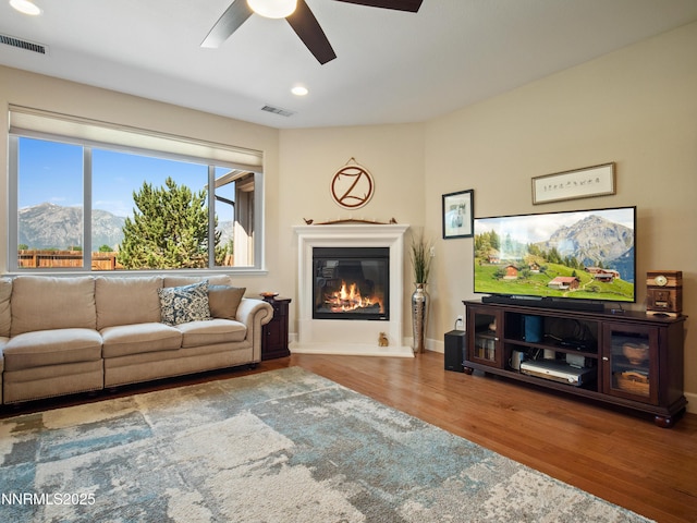 1221 Lasso Ln, Gardnerville, NV 89410 - living room featuring a ceiling fan, wood finished floors, a glass covered fireplace, a mountain view, and recessed lighting