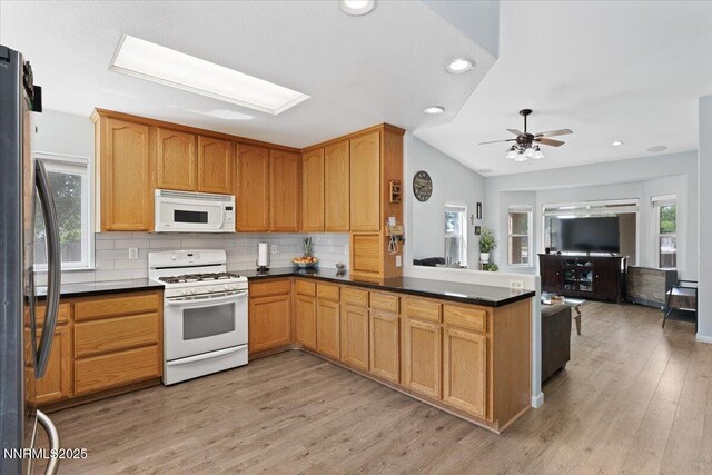 805 Samantha Cir, Fallon, NV 89406 - kitchen featuring white appliances, light wood finished floors, dark countertops, tasteful backsplash, and open floor plan