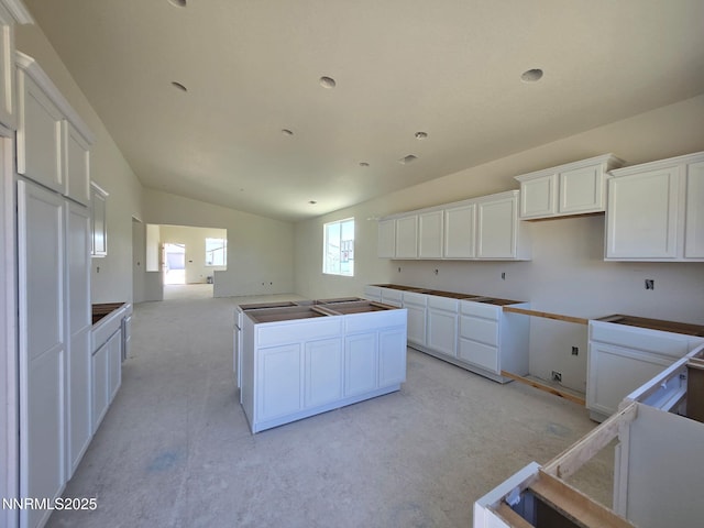 4059 Cone Peak Ct, Reno, NV 89508 - kitchen featuring a kitchen island, white cabinets, open floor plan, and vaulted ceiling