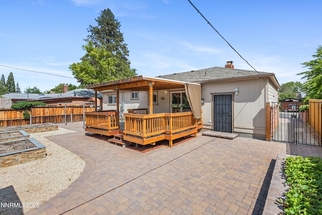2441 Riviera St, Reno, NV 89509 - back of house with a wooden deck, a gate, a chimney, and a patio area
