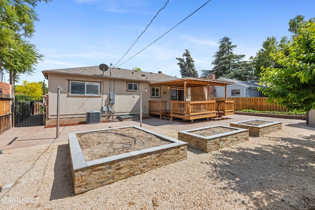 2441 Riviera St, Reno, NV 89509 - rear view of property with a wooden deck, a vegetable garden, a patio, and cooling unit