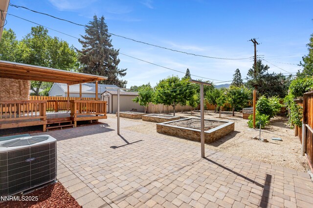 2441 Riviera St, Reno, NV 89509 - fenced backyard featuring central air condition unit, a patio area, a vegetable garden, and a wooden deck