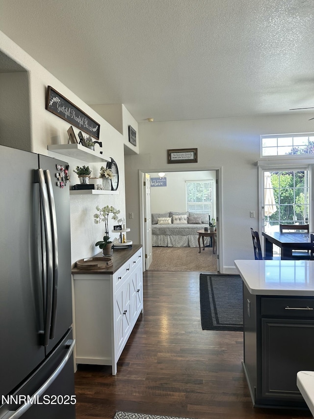 2787 Foxhill Dr, Carson City, NV 89706 - kitchen with freestanding refrigerator, dark wood-type flooring, a textured ceiling, open floor plan, and dark cabinetry