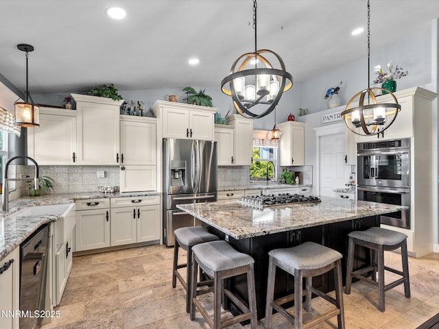 15 Cormorant Ct, Sparks, NV 89441 - kitchen with stainless steel appliances, a chandelier, a sink, tasteful backsplash, and recessed lighting