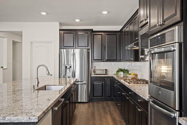 10450 Palladium Mine Dr, Reno, NV 89521 - kitchen featuring stainless steel appliances, a sink, dark wood-type flooring, light stone countertops, and recessed lighting