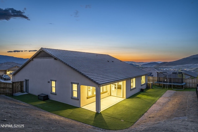 10450 Palladium Mine Dr, Reno, NV 89521 - back of property with a trampoline, stucco siding, a patio, and a tiled roof