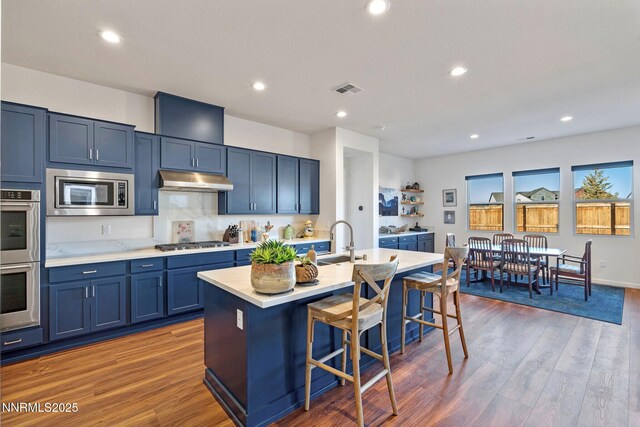 7415 Hoback Dr, Sparks, NV 89436 - kitchen featuring appliances with stainless steel finishes, a kitchen breakfast bar, blue cabinetry, light countertops, and a sink