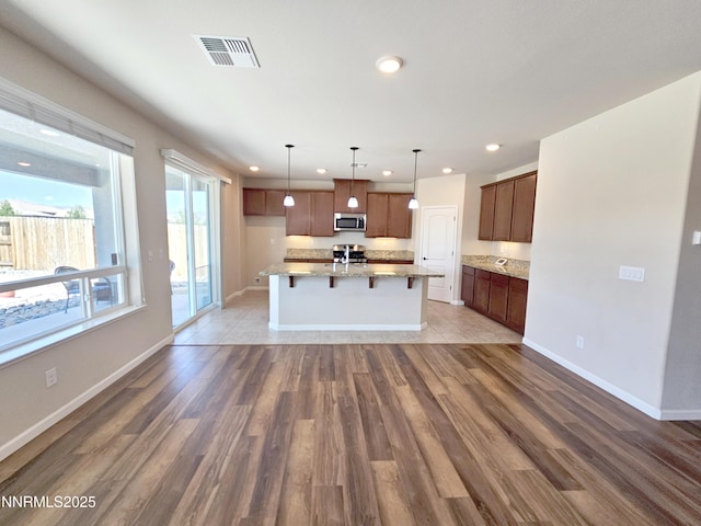217 Bristol Wells Ct, Spanish Springs, NV 89441 - kitchen with recessed lighting, light wood-type flooring, appliances with stainless steel finishes, light stone counters, and a breakfast bar area
