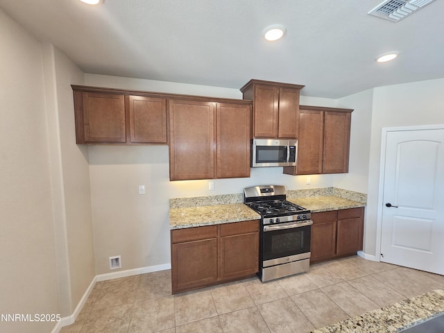 217 Bristol Wells Ct, Spanish Springs, NV 89441 - kitchen with stainless steel appliances, light stone countertops, baseboards, recessed lighting, and light tile patterned floors