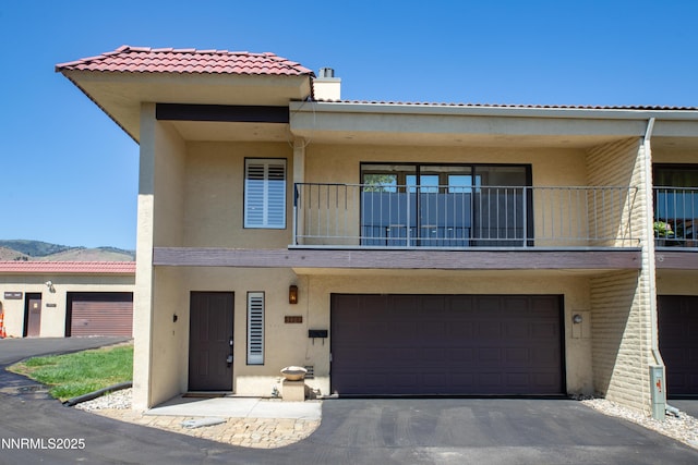 3467 Skyline Blvd, Reno, NV 89509 - view of front facade featuring stucco siding, a balcony, a tiled roof, and driveway