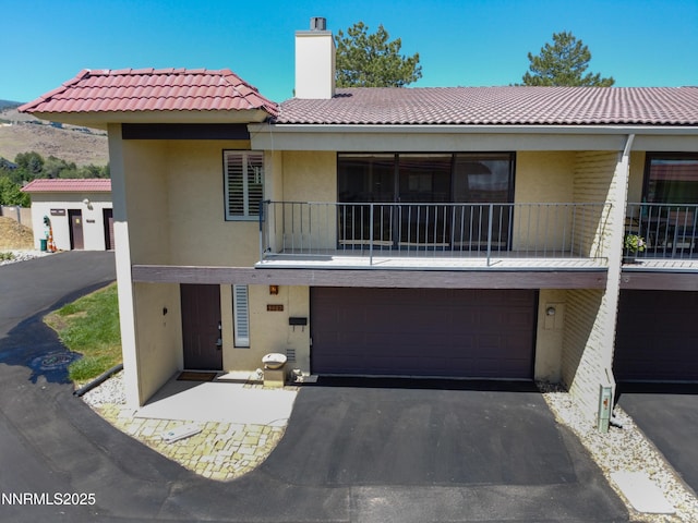3467 Skyline Blvd, Reno, NV 89509 - view of property with a tiled roof, stucco siding, a balcony, and a garage