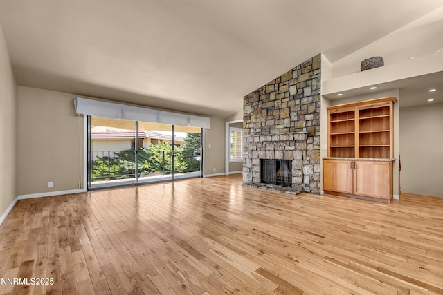 3467 Skyline Blvd, Reno, NV 89509 - unfurnished living room featuring lofted ceiling, light wood finished floors, a stone fireplace, and baseboards