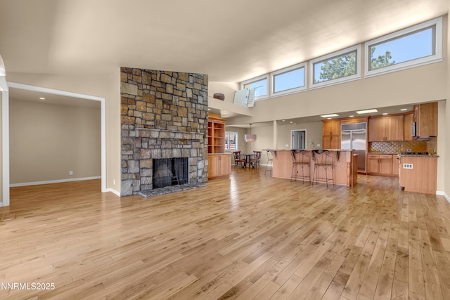 3467 Skyline Blvd, Reno, NV 89509 - living area featuring a towering ceiling, light wood-style flooring, a fireplace, and baseboards