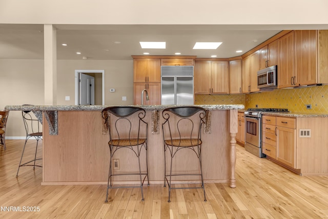 3467 Skyline Blvd, Reno, NV 89509 - kitchen featuring stainless steel appliances, a breakfast bar area, light wood-style floors, and recessed lighting