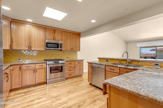3467 Skyline Blvd, Reno, NV 89509 - kitchen with stainless steel appliances, a sink, light wood-type flooring, tasteful backsplash, and light stone counters