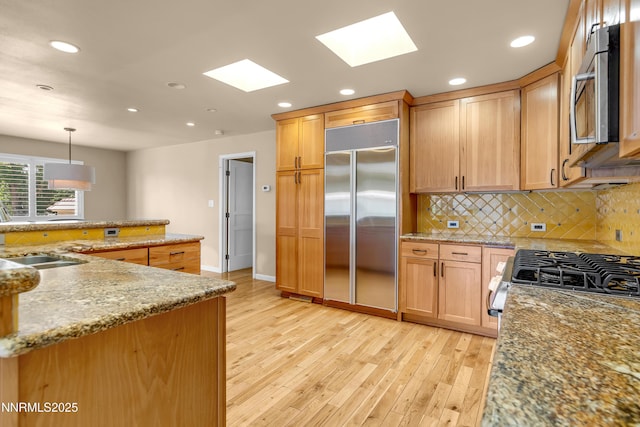 3467 Skyline Blvd, Reno, NV 89509 - kitchen featuring appliances with stainless steel finishes, a sink, light wood-style floors, recessed lighting, and a skylight