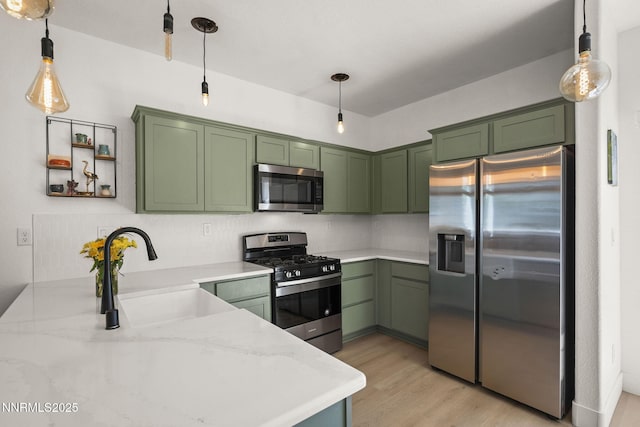 3621 Pimlico St, Reno, NV 89512 - kitchen with stainless steel appliances, green cabinets, light wood-style flooring, and hanging light fixtures