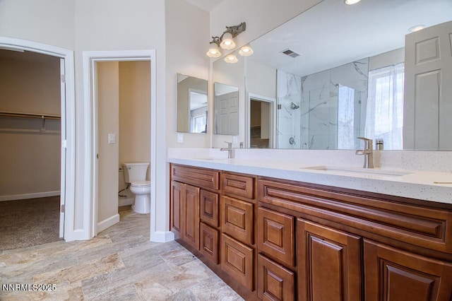 10595 Baton Ct, Reno, NV 89521 - full bathroom with double vanity, a marble finish shower, toilet, a spacious closet, and baseboards