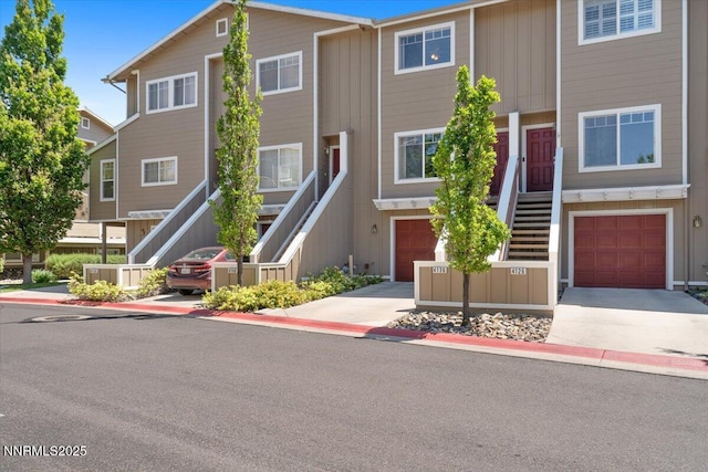 4136 Kathleen Denise Ln, Reno, NV 89503 - townhome / multi-family property featuring stairway, an attached garage, concrete driveway, and board and batten siding