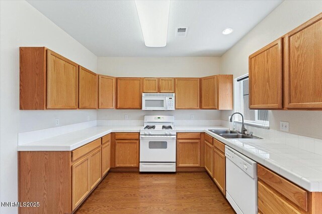 4136 Kathleen Denise Ln, Reno, NV 89503 - kitchen with white appliances, a sink, wood finished floors, and light countertops