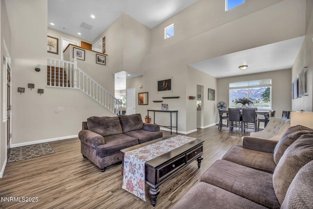 3250 Eaglewood Dr, Reno, NV 89502 - living area with wood finished floors, stairway, baseboards, a towering ceiling, and recessed lighting