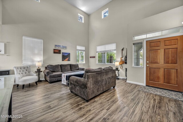 3250 Eaglewood Dr, Reno, NV 89502 - living area with wood finished floors, a towering ceiling, healthy amount of natural light, and baseboards