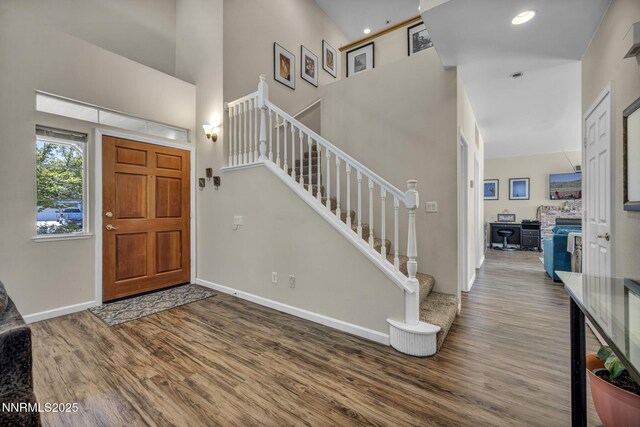 3250 Eaglewood Dr, Reno, NV 89502 - foyer entrance featuring wood finished floors, a towering ceiling, stairway, and baseboards