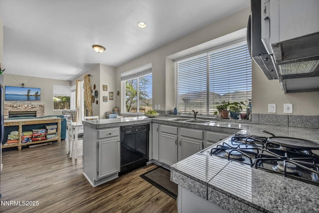 3250 Eaglewood Dr, Reno, NV 89502 - kitchen featuring dishwasher, tile counters, a sink, a peninsula, and stovetop