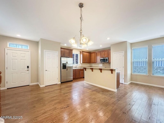 2180 Alamo Square Way, Reno, NV 89509 - kitchen with appliances with stainless steel finishes, a chandelier, a kitchen bar, light countertops, and recessed lighting