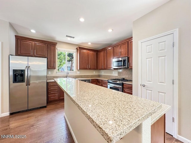 2180 Alamo Square Way, Reno, NV 89509 - kitchen featuring stainless steel appliances, light wood-style floors, a center island, recessed lighting, and light stone counters