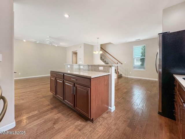 2180 Alamo Square Way, Reno, NV 89509 - kitchen with open floor plan, light wood-style flooring, freestanding refrigerator, hanging light fixtures, and a center island