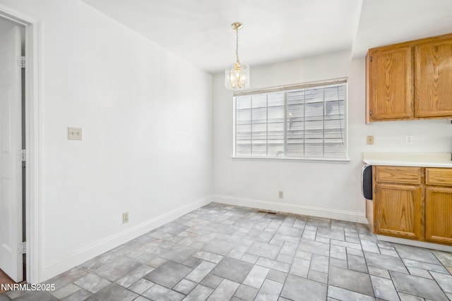 7554 Whimbleton Way, Reno, NV 89511 - unfurnished dining area with stone finish flooring, baseboards, and a chandelier