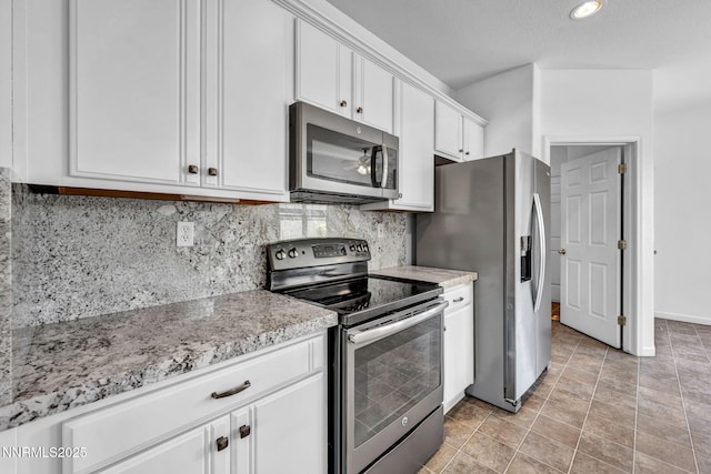 10559 Iron Point Cir, Reno, NV 89521 - kitchen with stainless steel appliances, white cabinets, backsplash, light stone counters, and recessed lighting