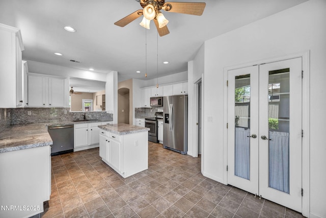 10559 Iron Point Cir, Reno, NV 89521 - kitchen with stainless steel appliances, a ceiling fan, french doors, decorative backsplash, and a center island