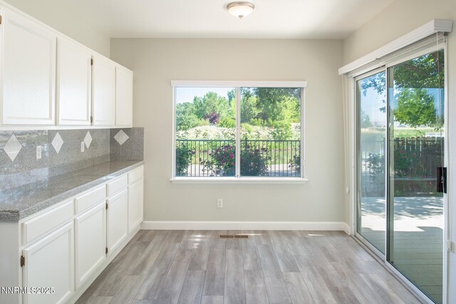 4734 Tierrapark Ct, Reno, NV 89502 - kitchen featuring light wood finished floors, white cabinets, tasteful backsplash, and light stone counters